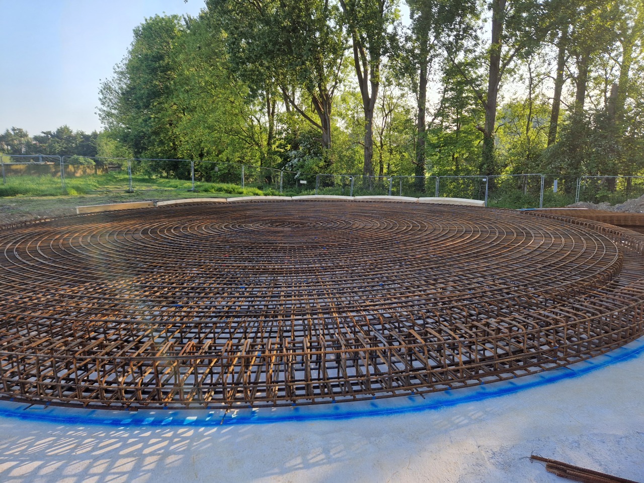 Large circular wind turbine foundation rebar mat — full ground-level view of completed concentric ring reinforcement