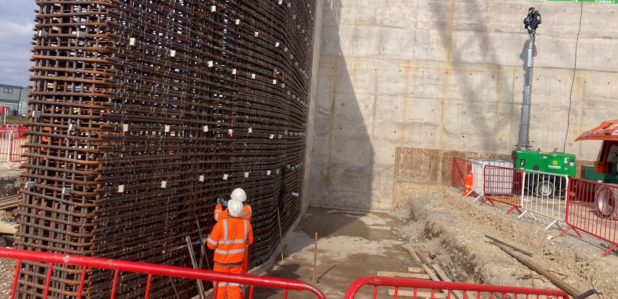 Quick-Steel-Fix steel fixer working a tall wall reinforcement cage in full PPE