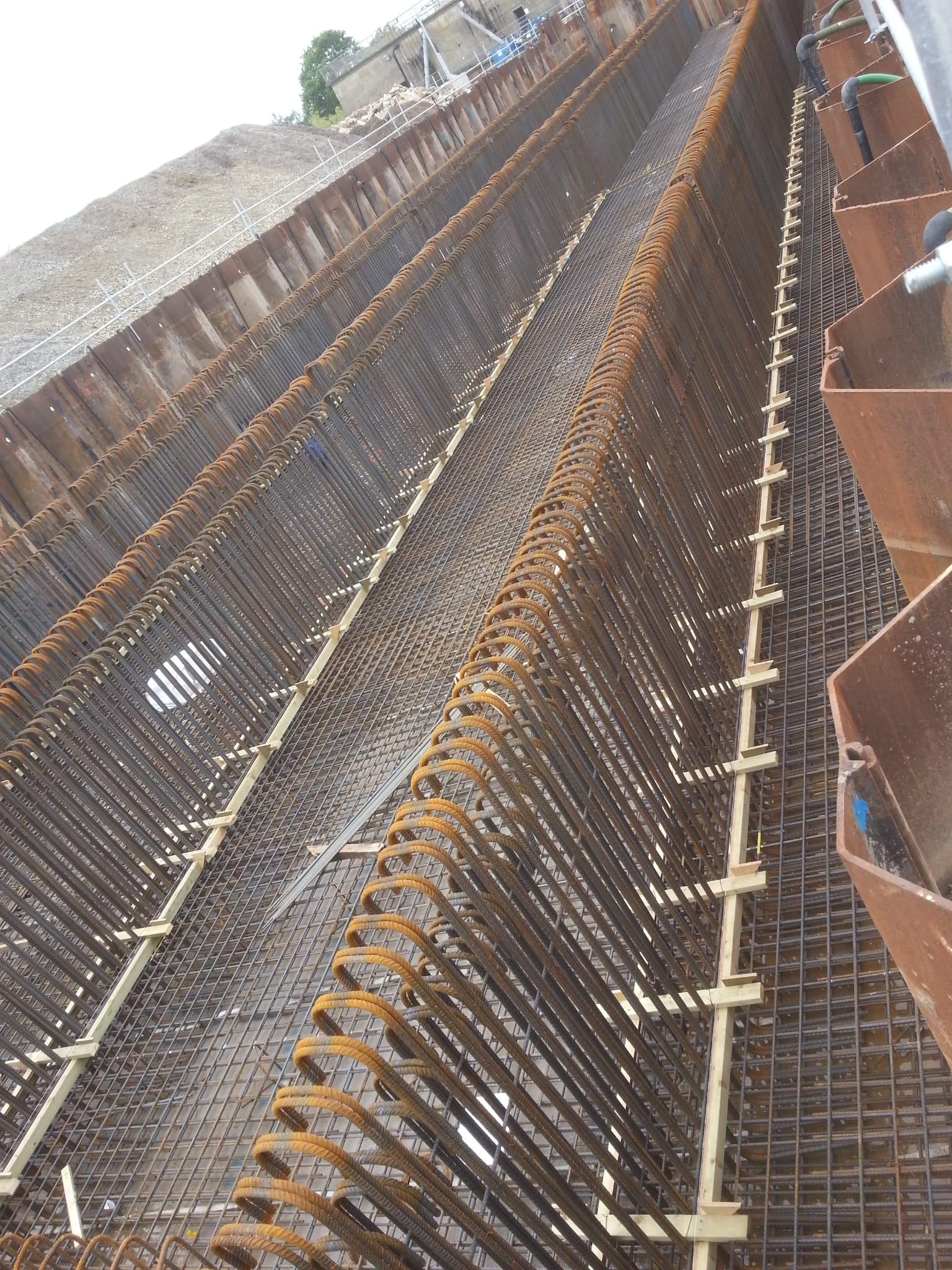 Long deep retaining wall reinforcement with diagonal struts and horizontal bands
